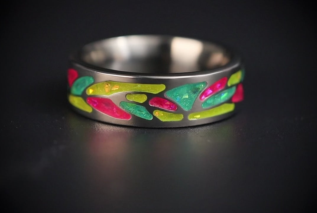 Arcadia titanium ring featuring a colorful abstract inlay with multi-color glow-in-the-dark elements inspired by retro arcade aesthetics.