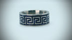 Titanium ring with Greek key pattern inlaid with blue goldstone and silver leaf creating a galaxy-like effect.