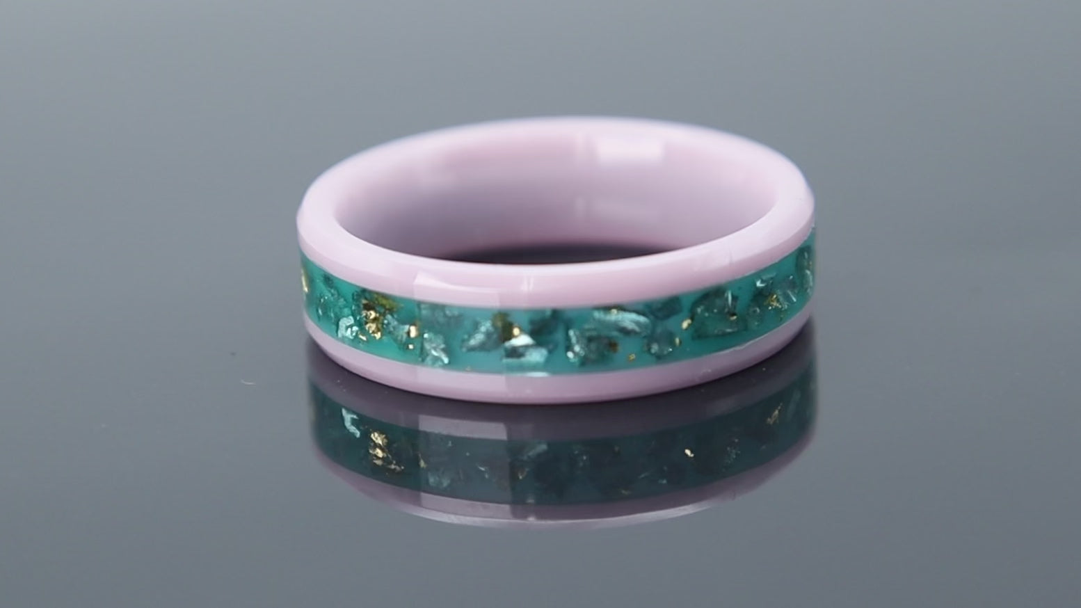 Ceramic ring with pink base, teal inlay and gold leaf reflecting sunset and ocean tones
