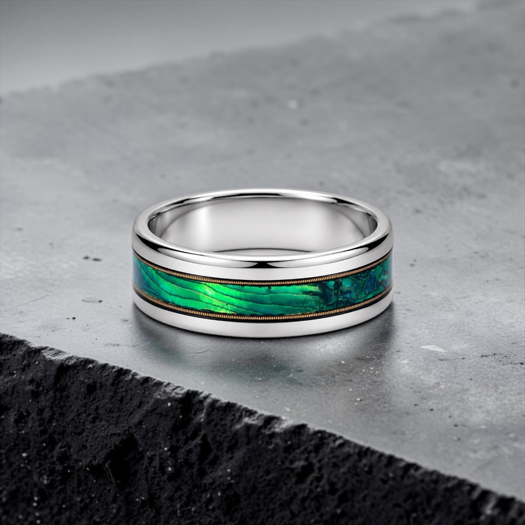 Polished titanium ring with paua abalone inlay and brass guitar strings, handcrafted for everyday wear