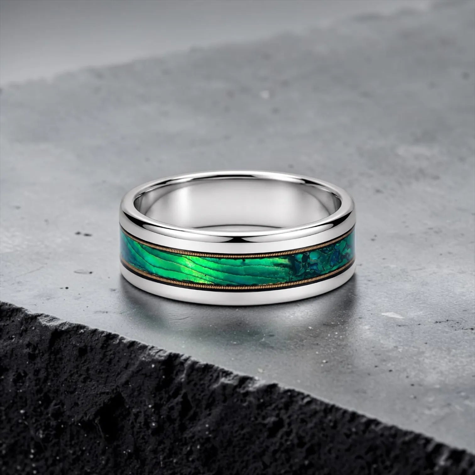 Polished titanium ring with paua abalone inlay and brass guitar strings, handcrafted for everyday wear