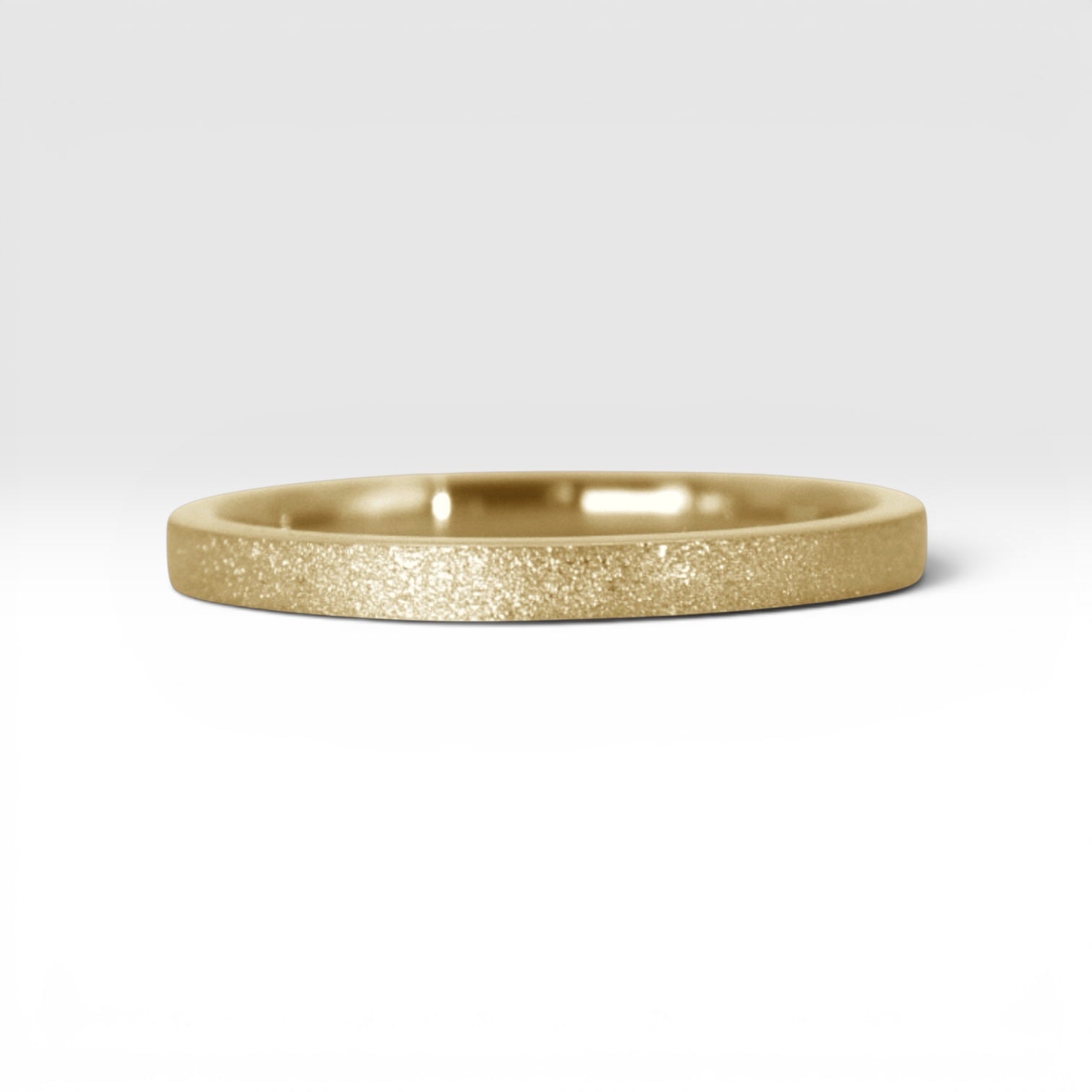 Órbita Luz 2mm gold stackable ring with frosted finish, luminous surface, handcrafted in Utah