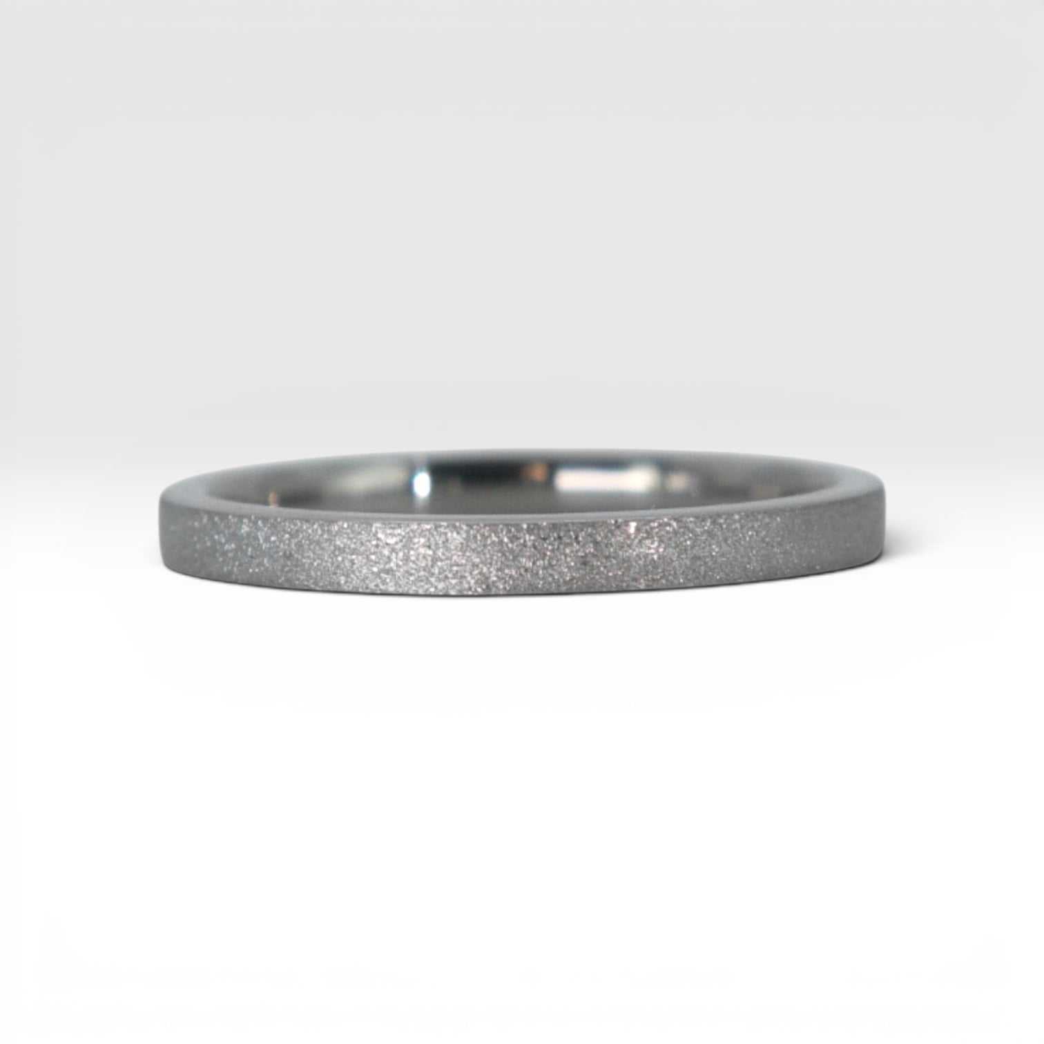 Órbita Luz 2mm titanium stackable ring with frosted finish, luminous surface, handcrafted in Utah