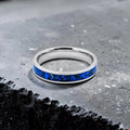 Close-up of titanium ring with chrysocolla inlay and silver leaf showing natural blue patterns and metallic texture