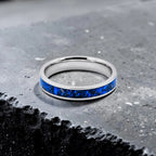 Close-up of titanium ring with chrysocolla inlay and silver leaf showing natural blue patterns and metallic texture
