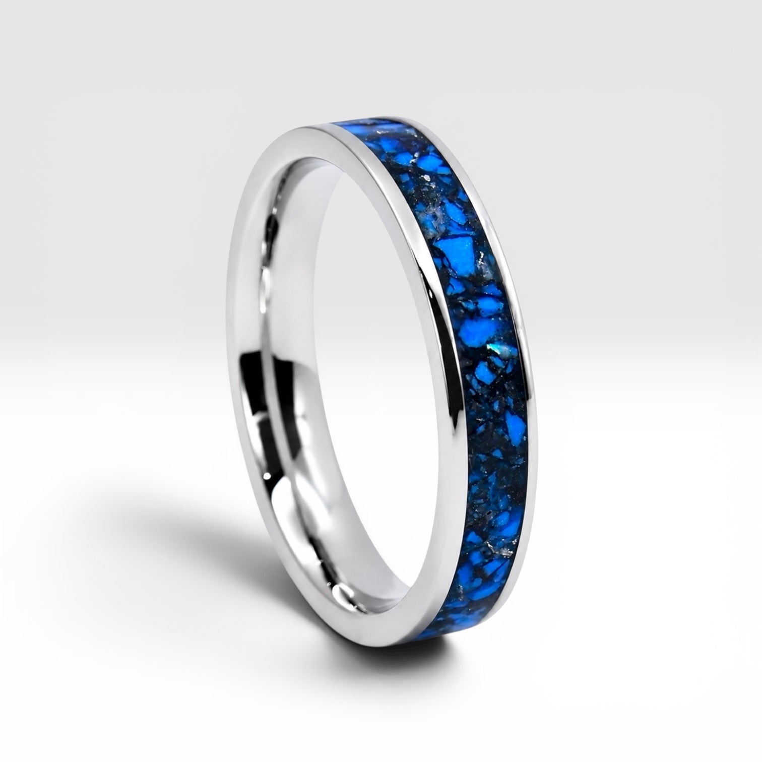 Close-up of titanium ring with chrysocolla inlay and silver leaf showing natural blue patterns and metallic texture
