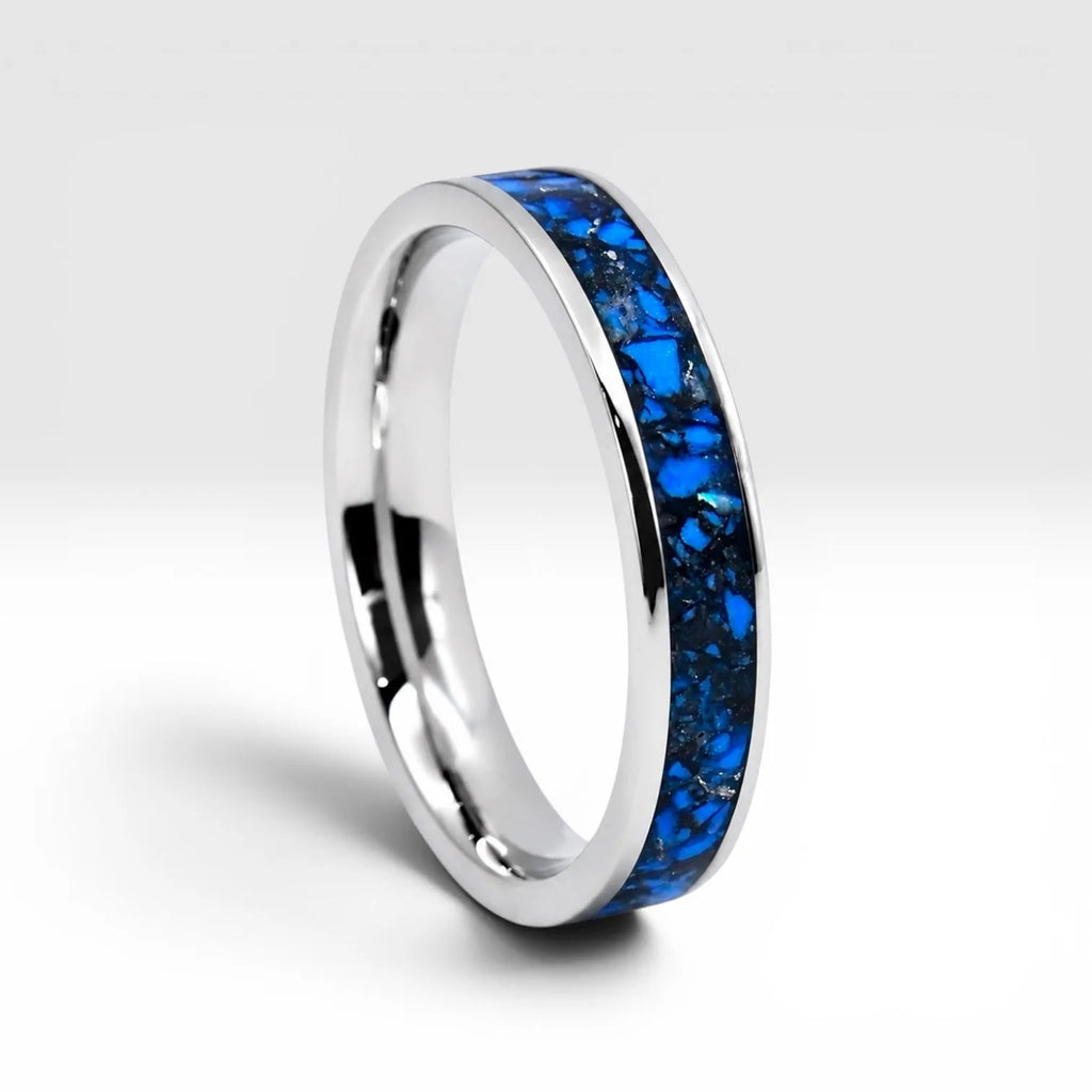 Close-up of titanium ring with chrysocolla inlay and silver leaf showing natural blue patterns and metallic texture