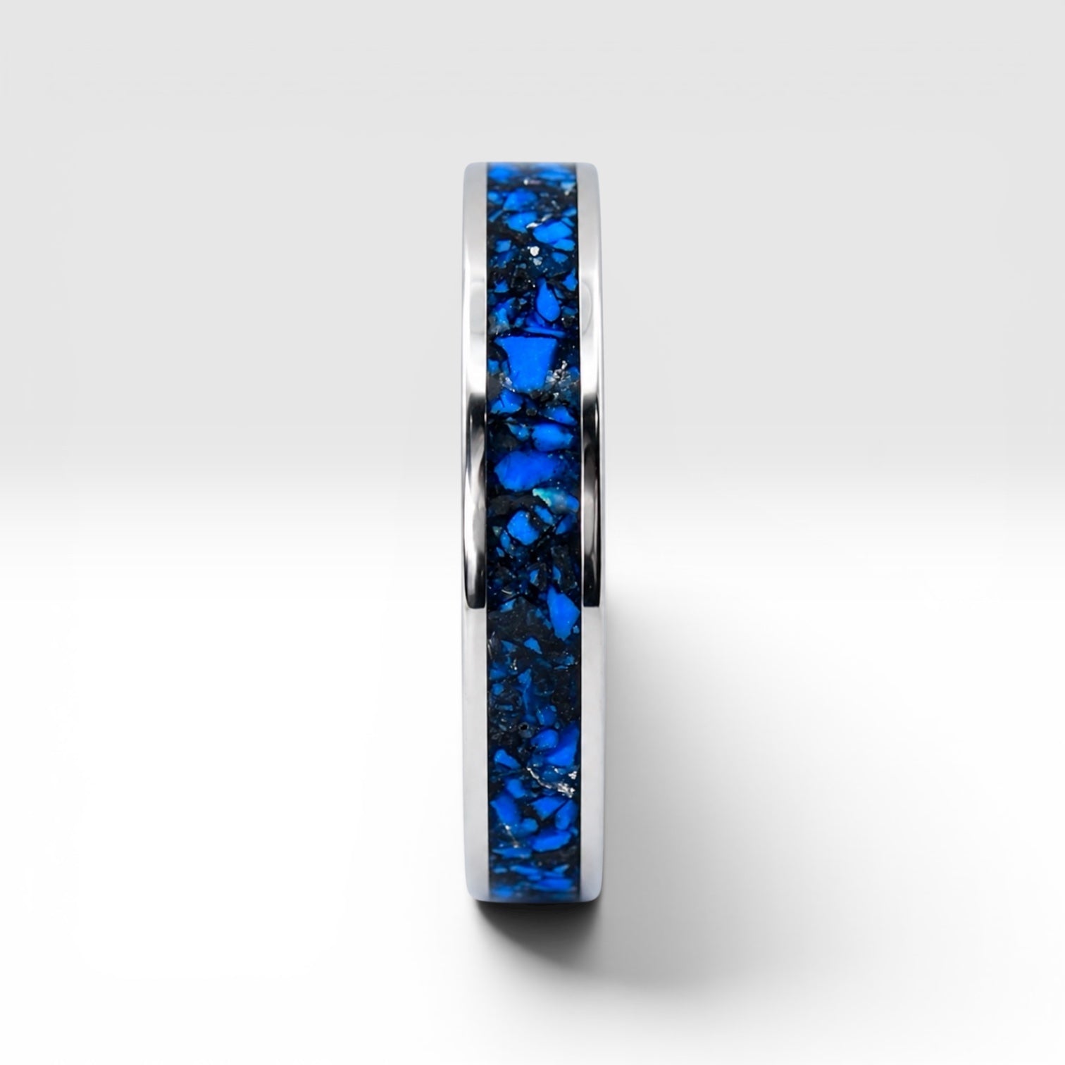 Close-up of titanium ring with chrysocolla inlay and silver leaf showing natural blue patterns and metallic texture