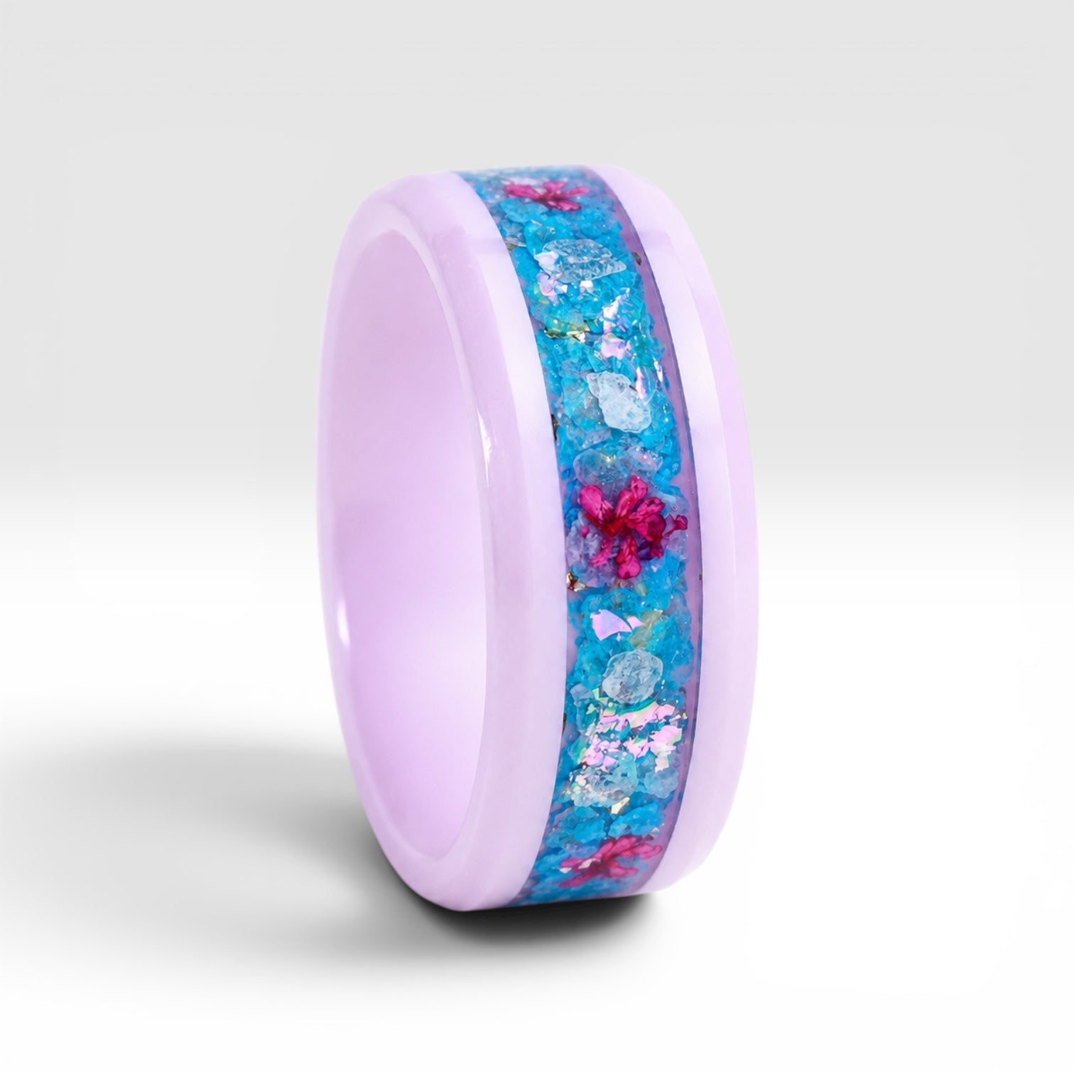 Skyblossom pink ceramic ring featuring preserved blue flower petals, pink pressed flowers, and iridescent accents in a handcrafted floral inlay.
