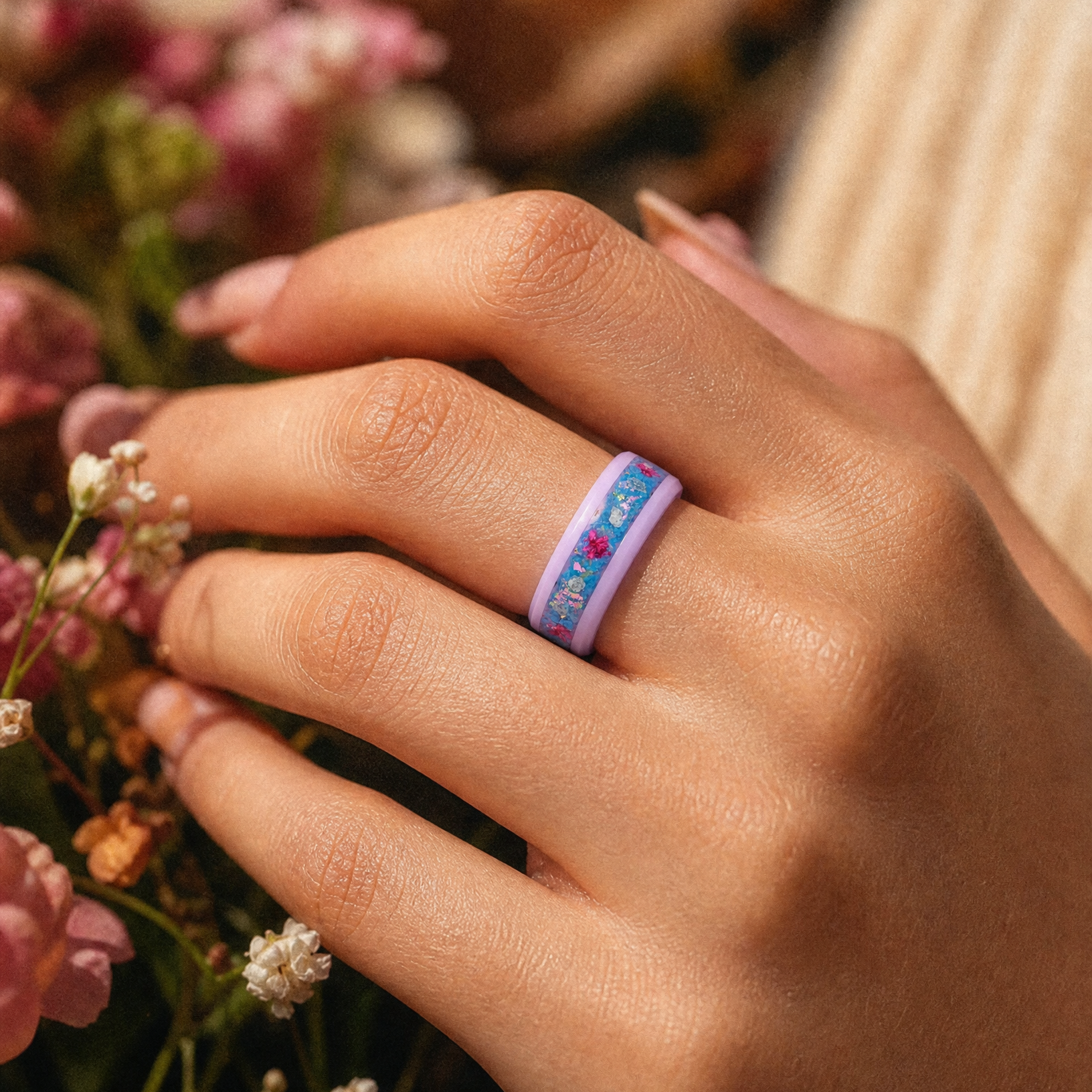 Skyblossom pink ceramic ring featuring preserved blue flower petals, pink pressed flowers, and iridescent accents in a handcrafted floral inlay.