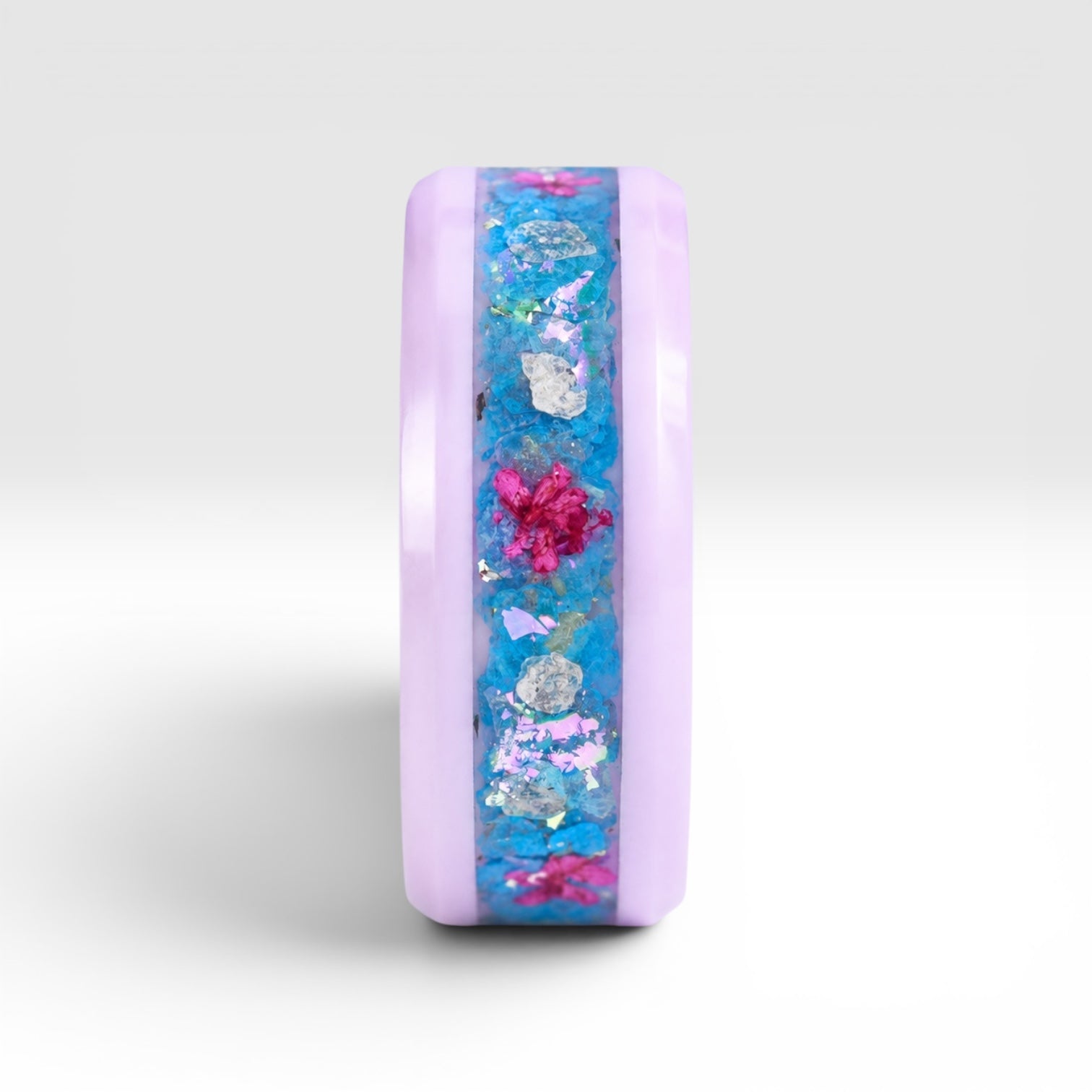 Skyblossom pink ceramic ring featuring preserved blue flower petals, pink pressed flowers, and iridescent accents in a handcrafted floral inlay.