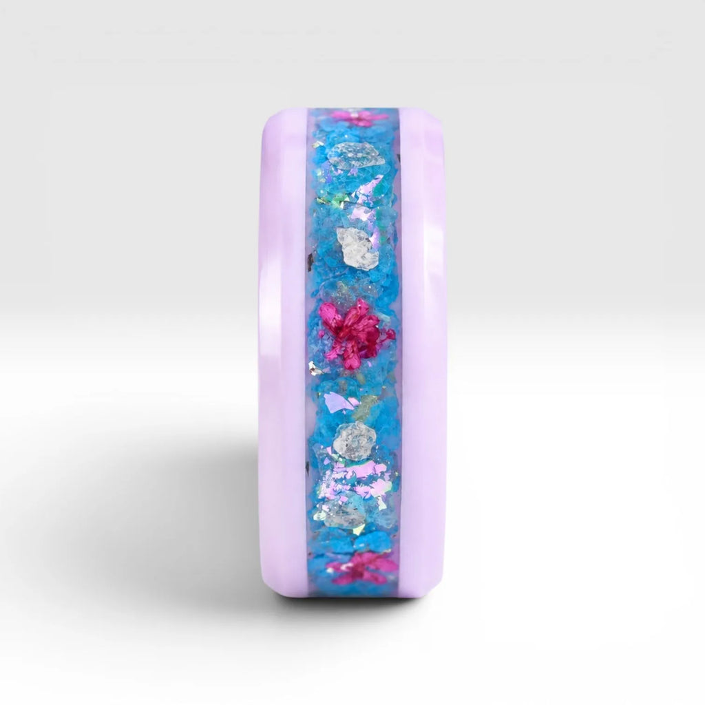 Skyblossom pink ceramic ring featuring preserved blue flower petals, pink pressed flowers, and iridescent accents in a handcrafted floral inlay.
