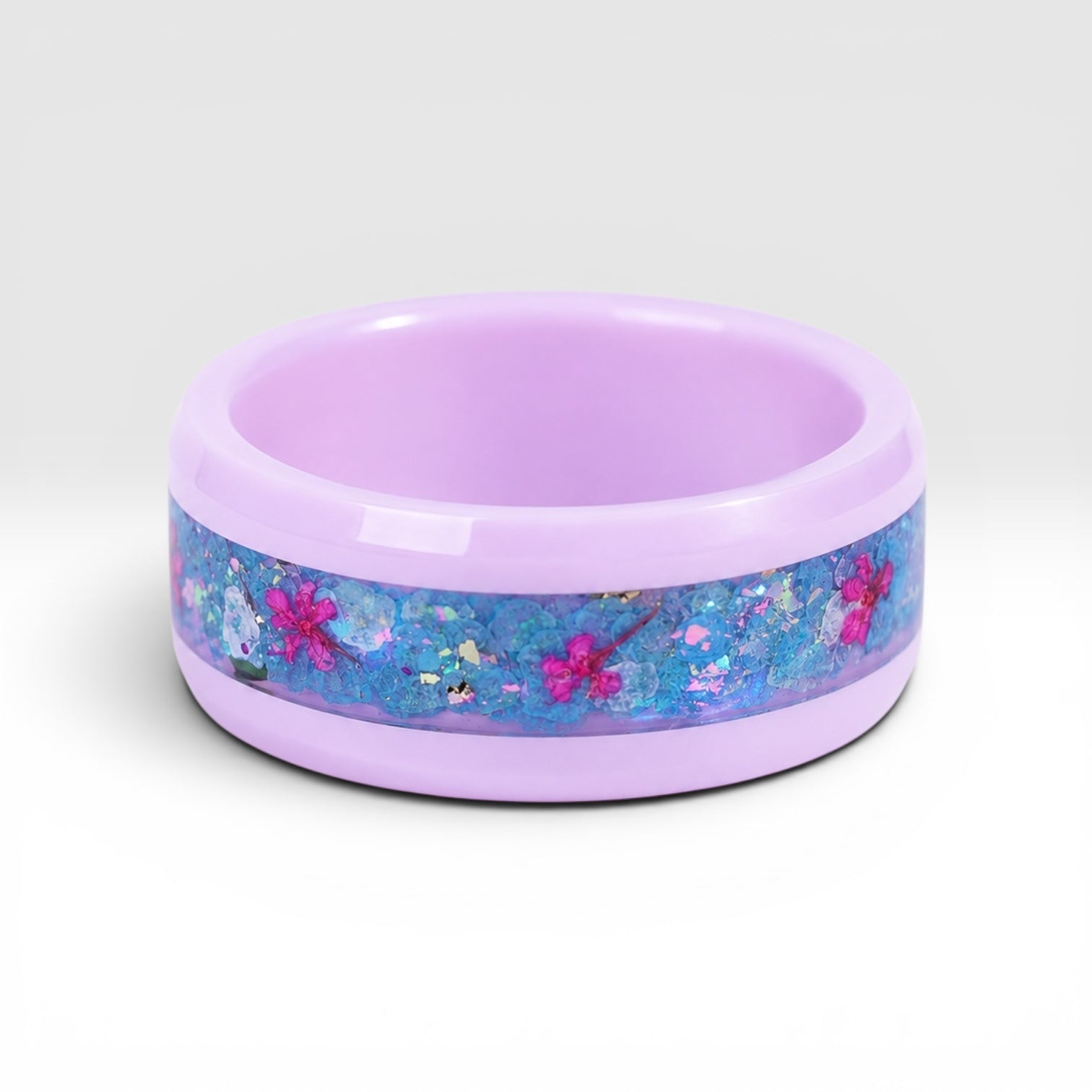 Skyblossom pink ceramic ring featuring preserved blue flower petals, pink pressed flowers, and iridescent accents in a handcrafted floral inlay.