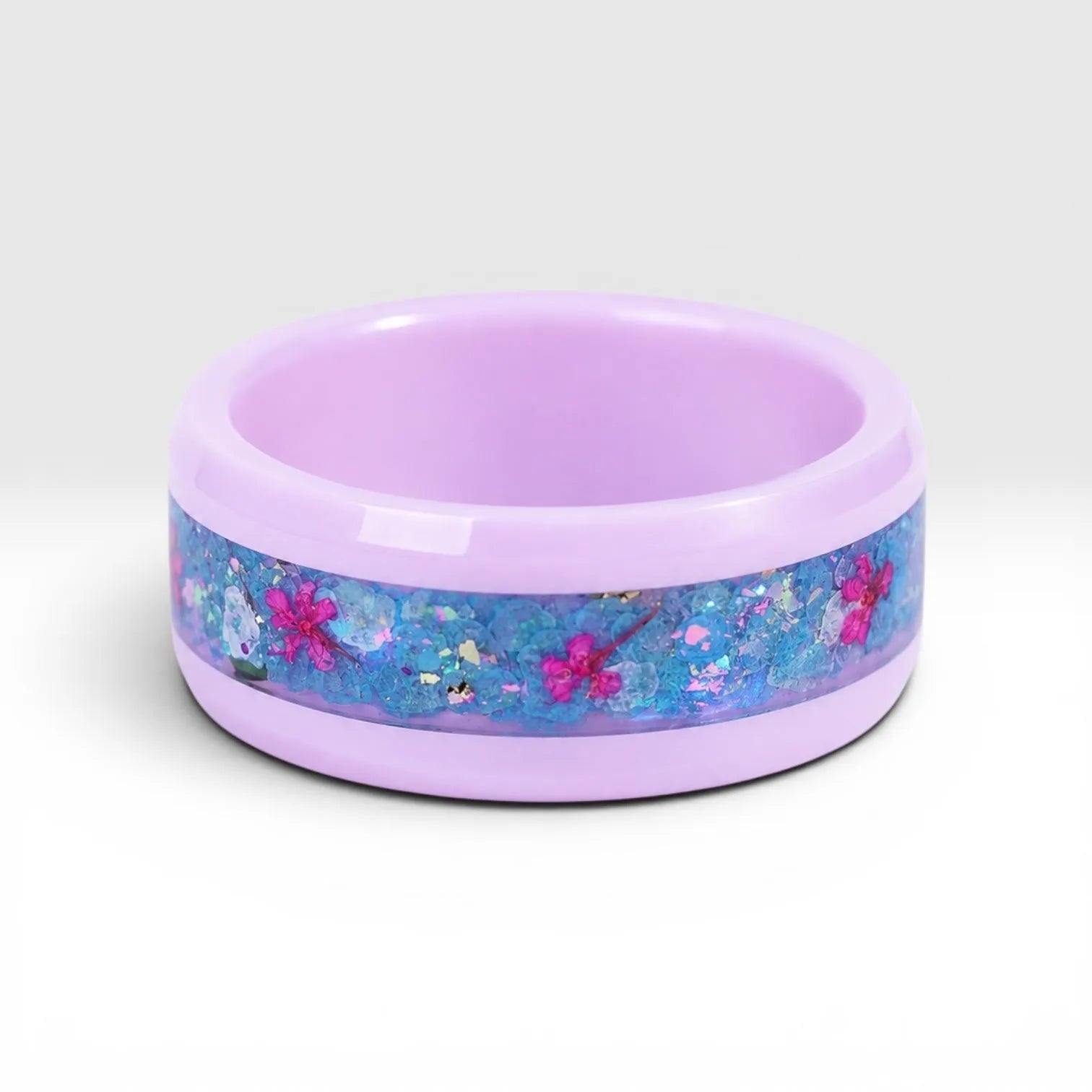 Skyblossom pink ceramic ring featuring preserved blue flower petals, pink pressed flowers, and iridescent accents in a handcrafted floral inlay.