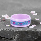Skyblossom pink ceramic ring featuring preserved blue flower petals, pink pressed flowers, and iridescent accents in a handcrafted floral inlay.