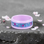 Skyblossom pink ceramic ring featuring preserved blue flower petals, pink pressed flowers, and iridescent accents in a handcrafted floral inlay.
