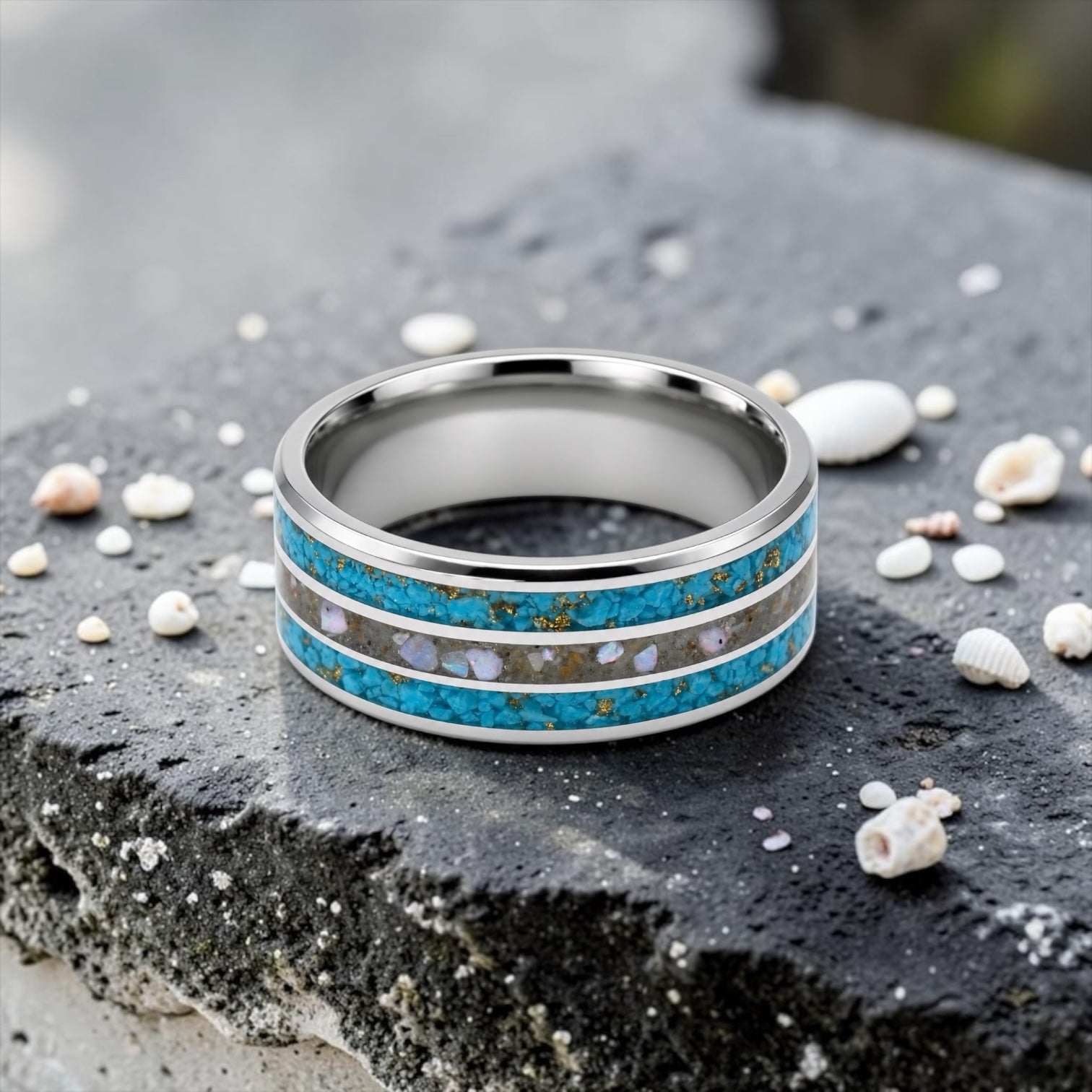 Close-up of tungsten ring with turquoise, mother of pearl and gold leaf showing layered ocean inspired inlay