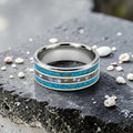 Close-up of tungsten ring with turquoise, mother of pearl and gold leaf showing layered ocean inspired inlay