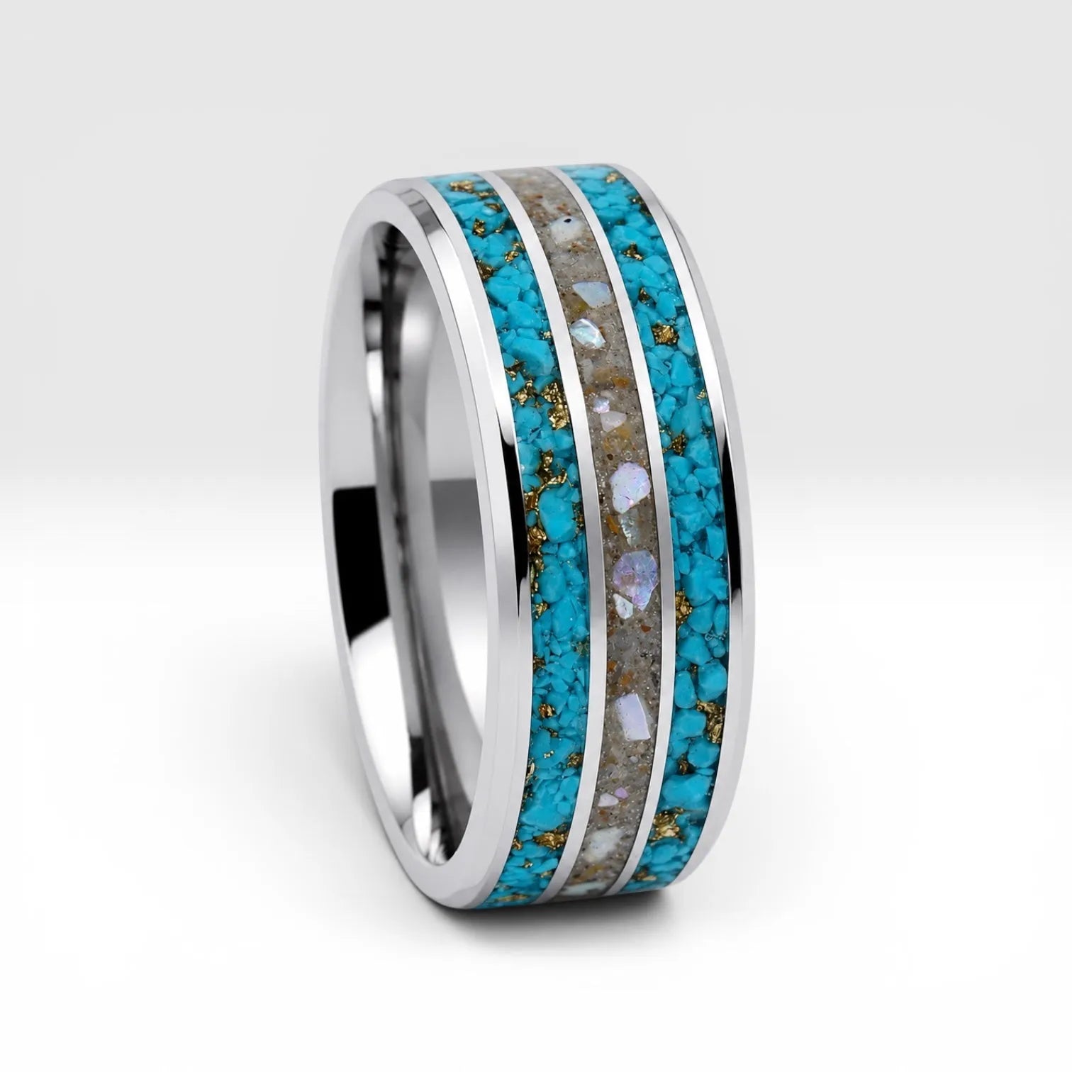 Close-up of tungsten ring with turquoise, mother of pearl and gold leaf showing layered ocean inspired inlay