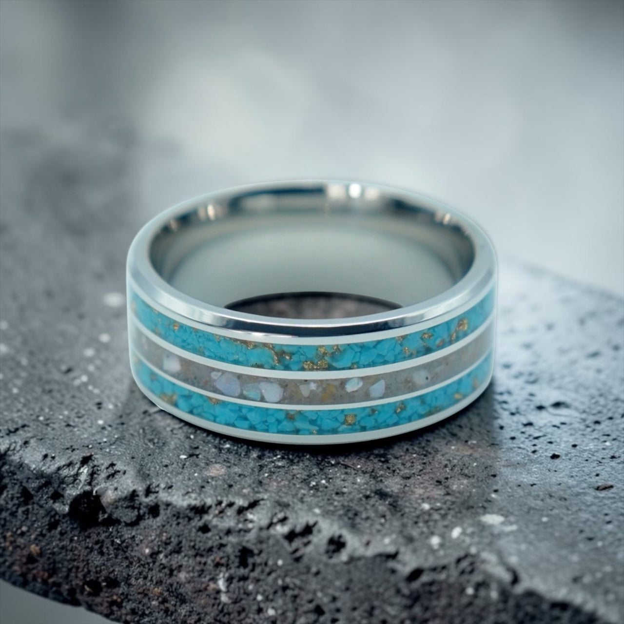 Close-up of tungsten ring with turquoise, mother of pearl and gold leaf showing layered ocean inspired inlay