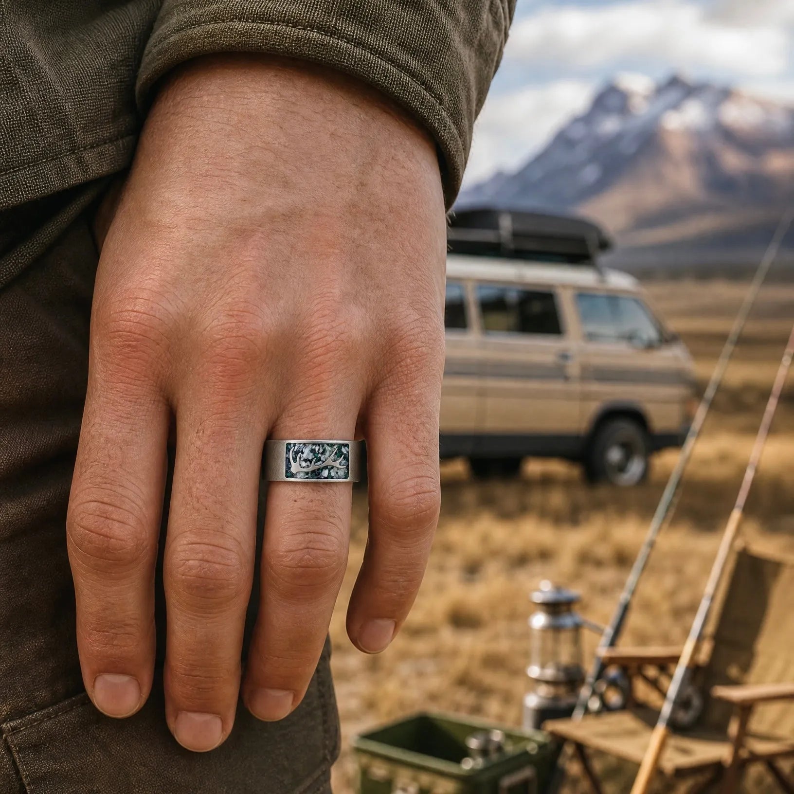 Stagline titanium ring featuring genuine crushed elk tooth, natural malachite inlay, and an antler silhouette with a distressed handcrafted finish.