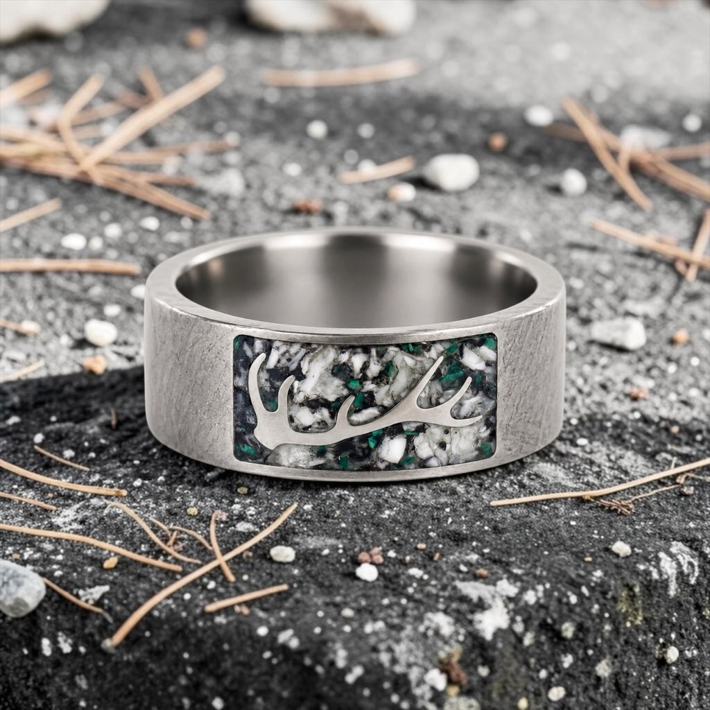 Stagline titanium ring featuring genuine crushed elk tooth, natural malachite inlay, and an antler silhouette with a distressed handcrafted finish.