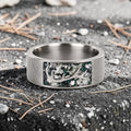 Stagline titanium ring featuring genuine crushed elk tooth, natural malachite inlay, and an antler silhouette with a distressed handcrafted finish.