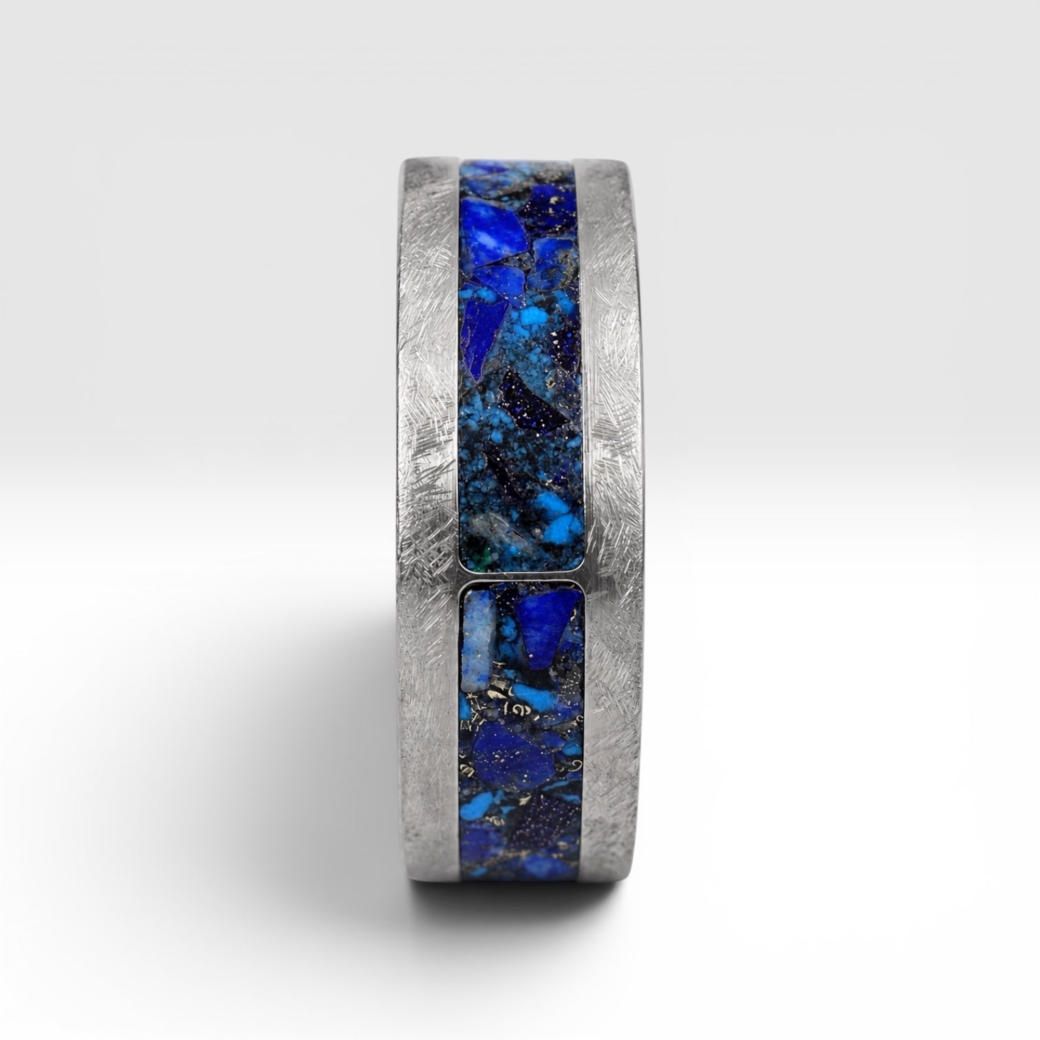 Stellaris titanium ring featuring a mosaic inlay of lapis lazuli, chrysocolla, turquoise, blue goldstone, and brass accents with a distressed finish.