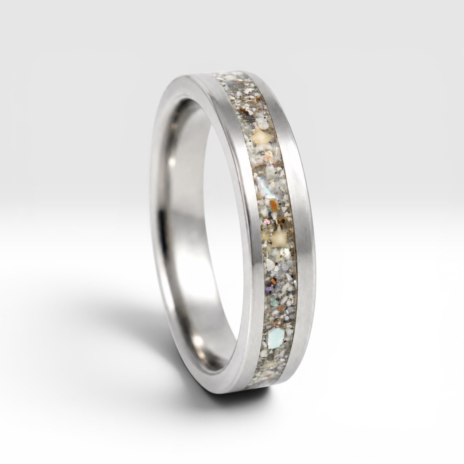 Stellatide titanium ring featuring Bermuda beach sand, Okinawa star sand, and mother of pearl inlay handcrafted by Venus Rings.