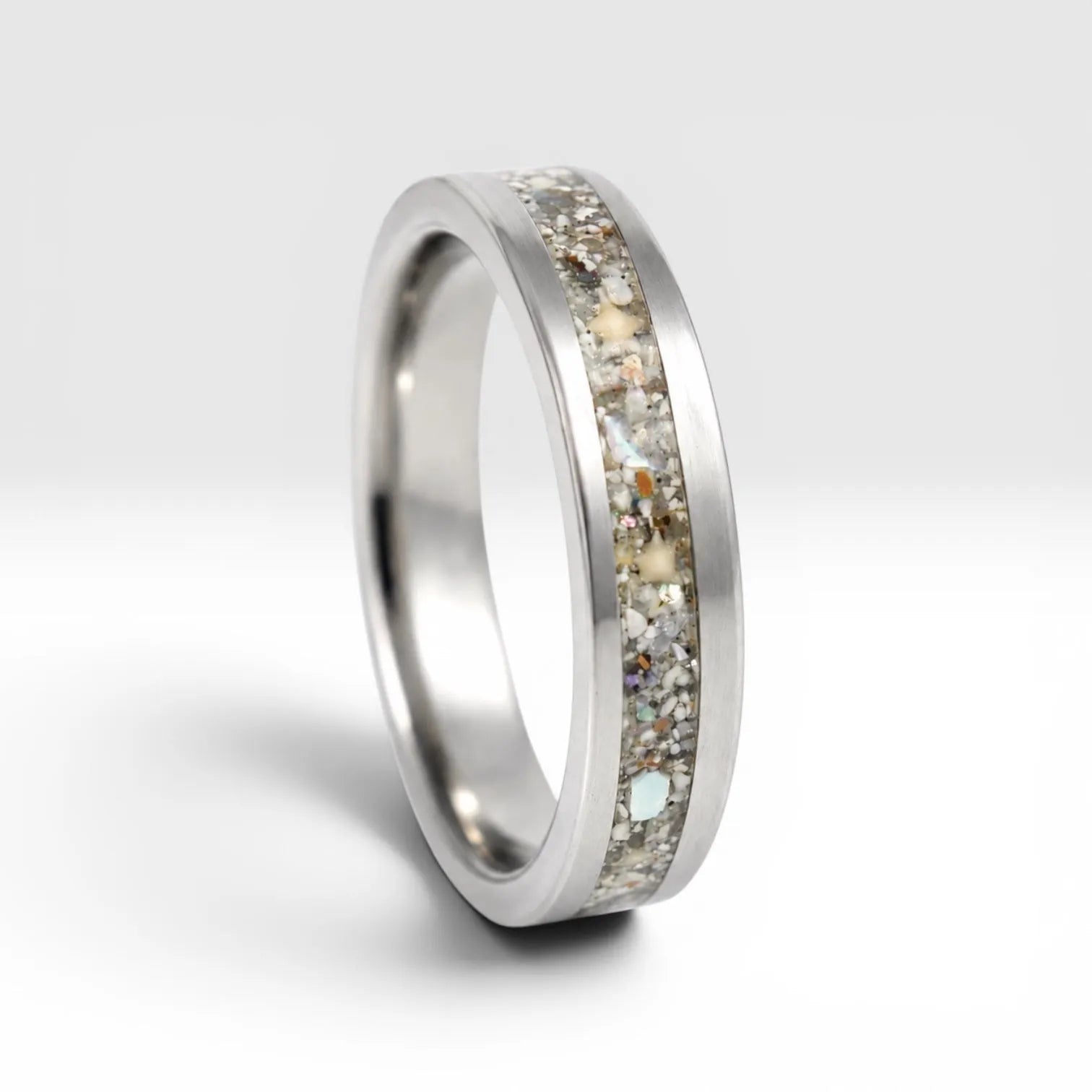 Stellatide titanium ring featuring Bermuda beach sand, Okinawa star sand, and mother of pearl inlay handcrafted by Venus Rings.