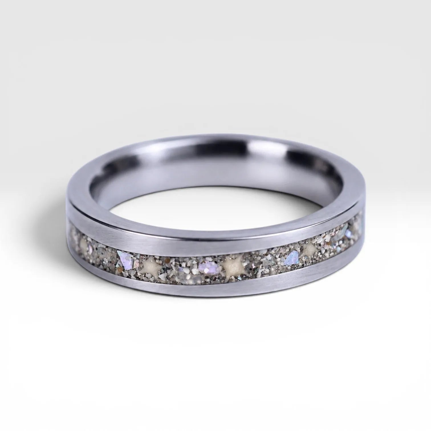Stellatide titanium ring featuring Bermuda beach sand, Okinawa star sand, and mother of pearl inlay handcrafted by Venus Rings.