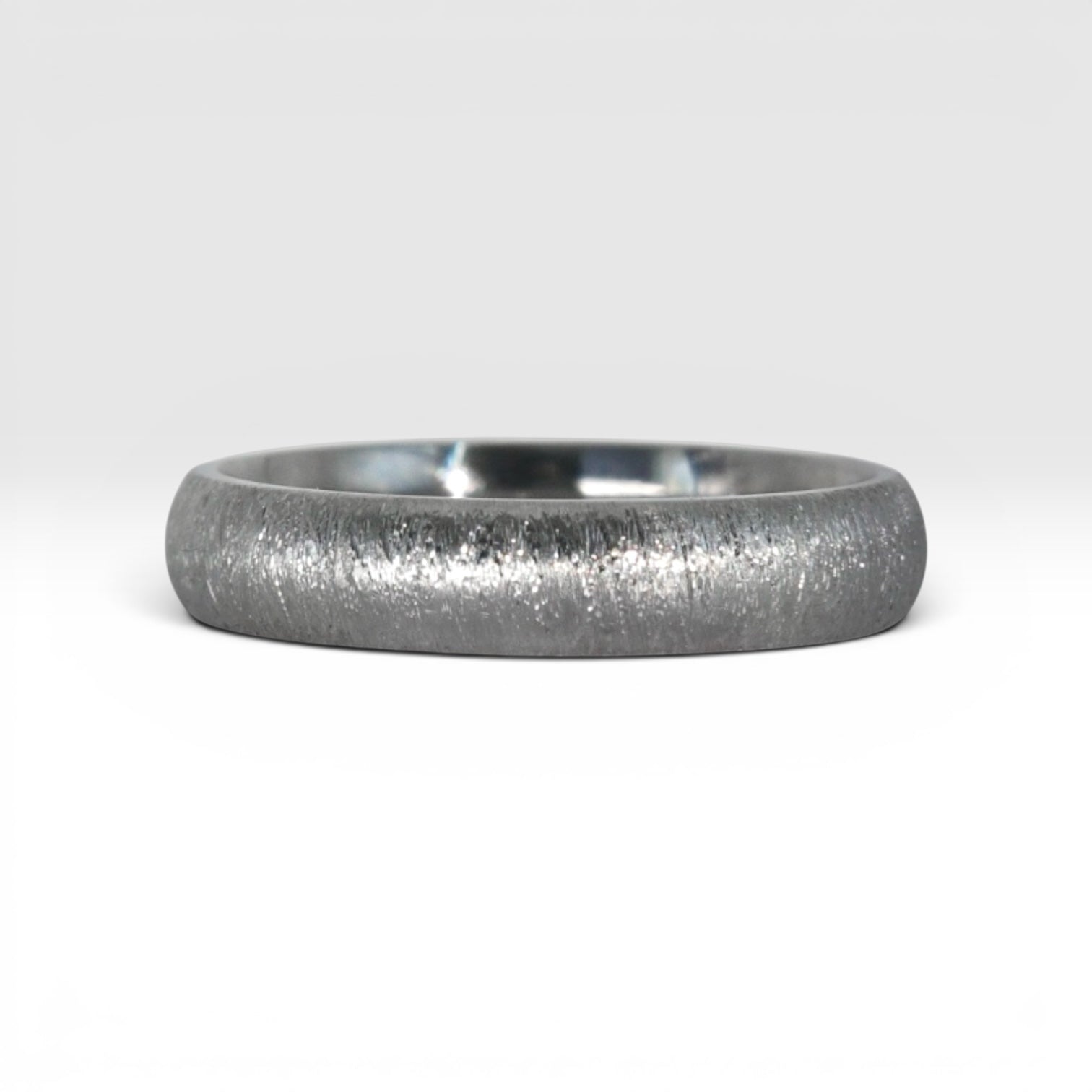 4mm domed titanium women's wedding band with fine vertical texture creating a luminous sparkle effect