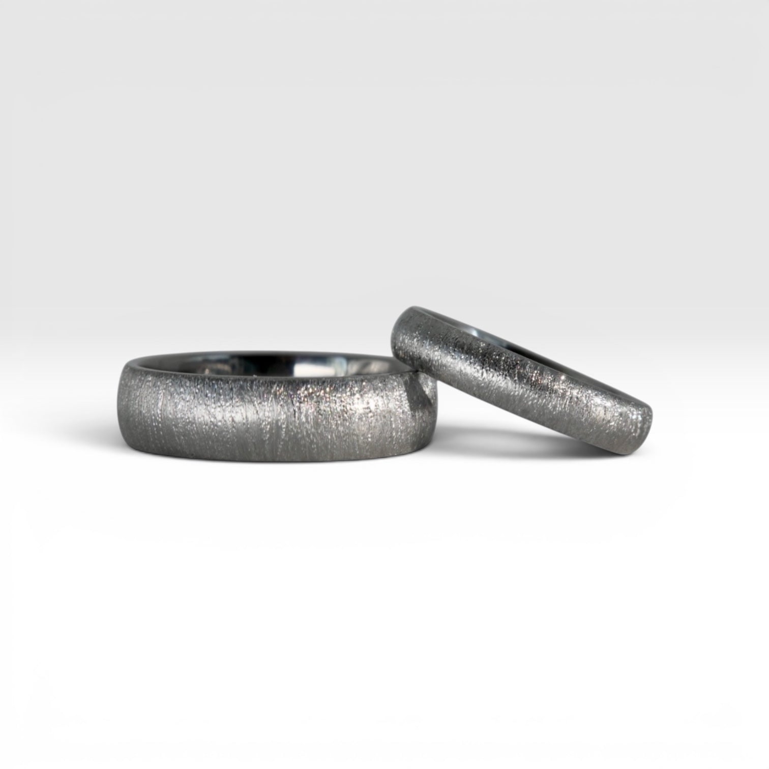 Matching domed titanium wedding band set, 6mm his and 4mm hers, with sparkle finish, handcrafted in Utah
