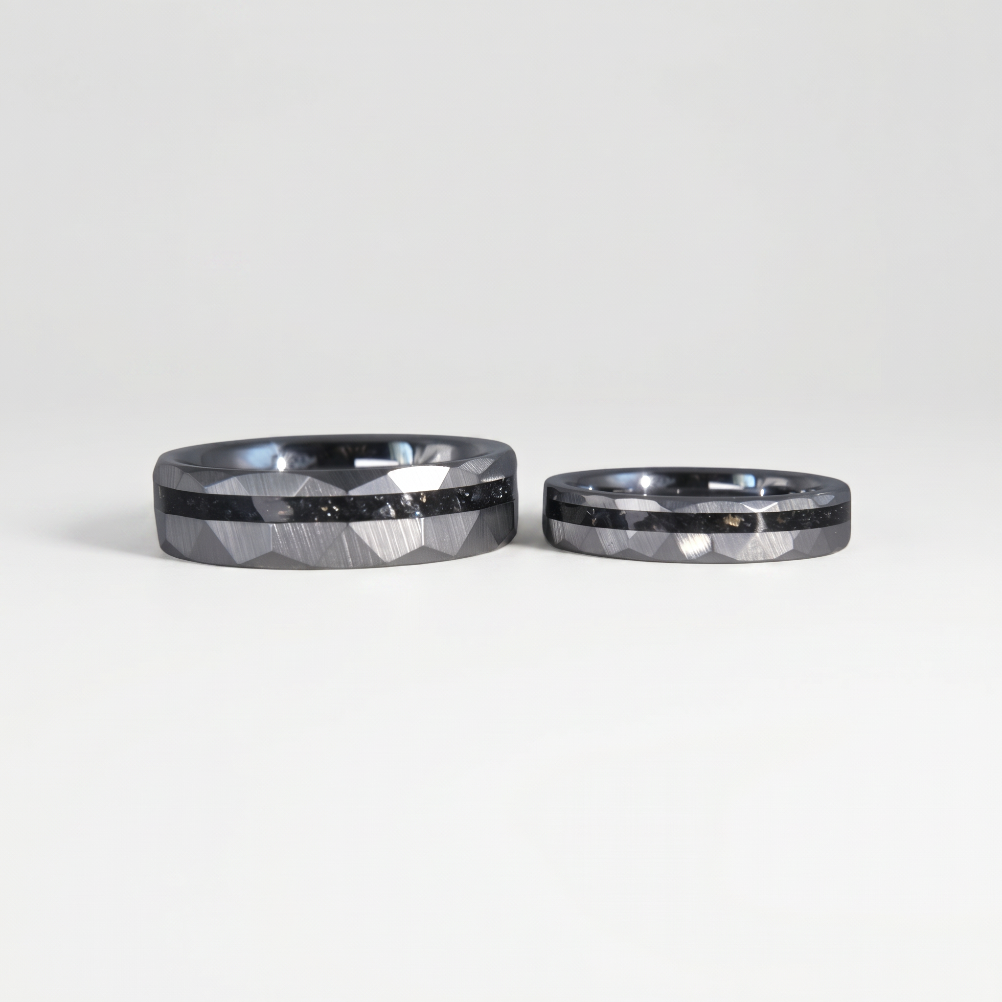 Slim tungsten wedding ring with black tourmaline and gold inlay, faceted finish with refined elegant design