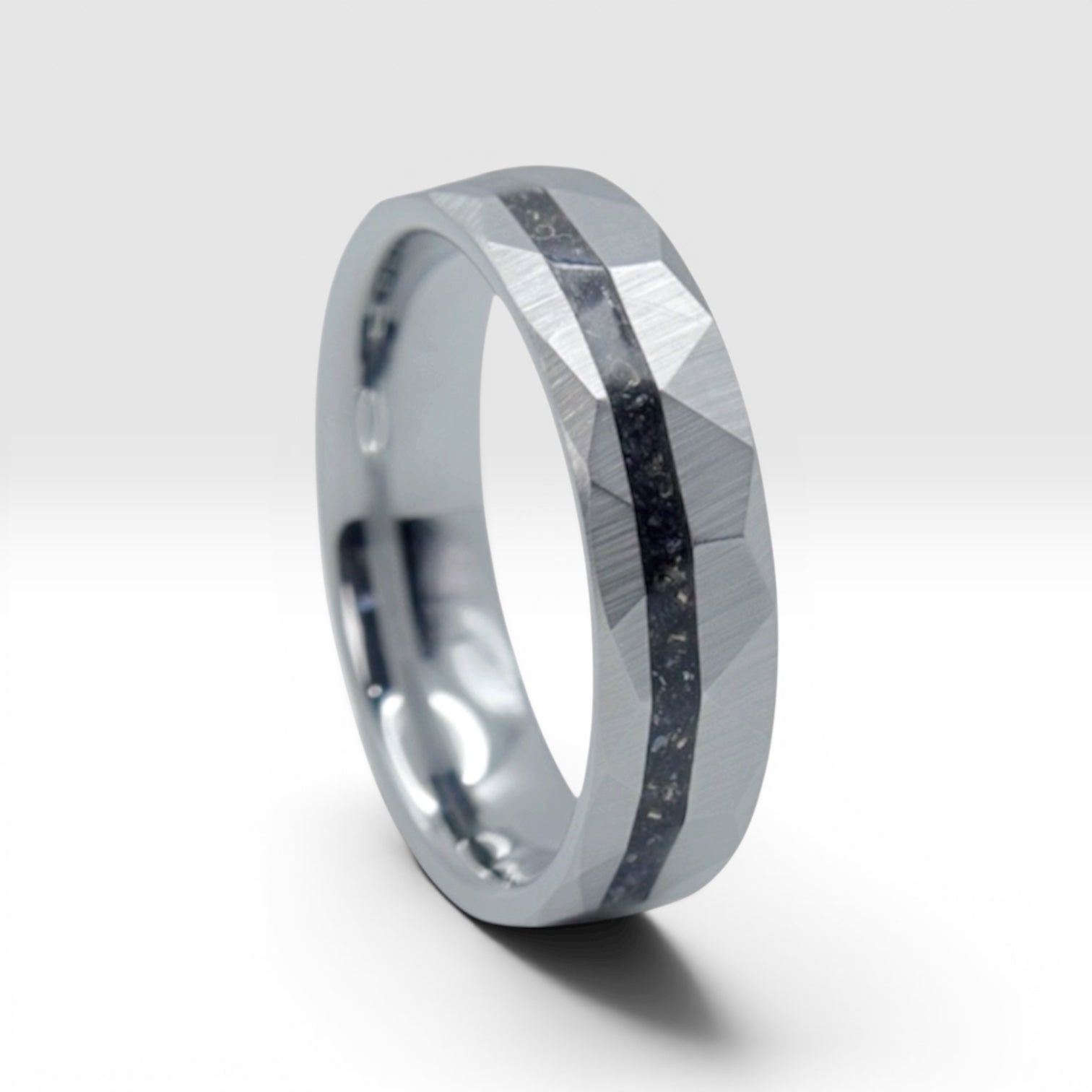 Faceted tungsten wedding ring with black tourmaline and 14k gold shavings inlay in a 2mm offset channel
