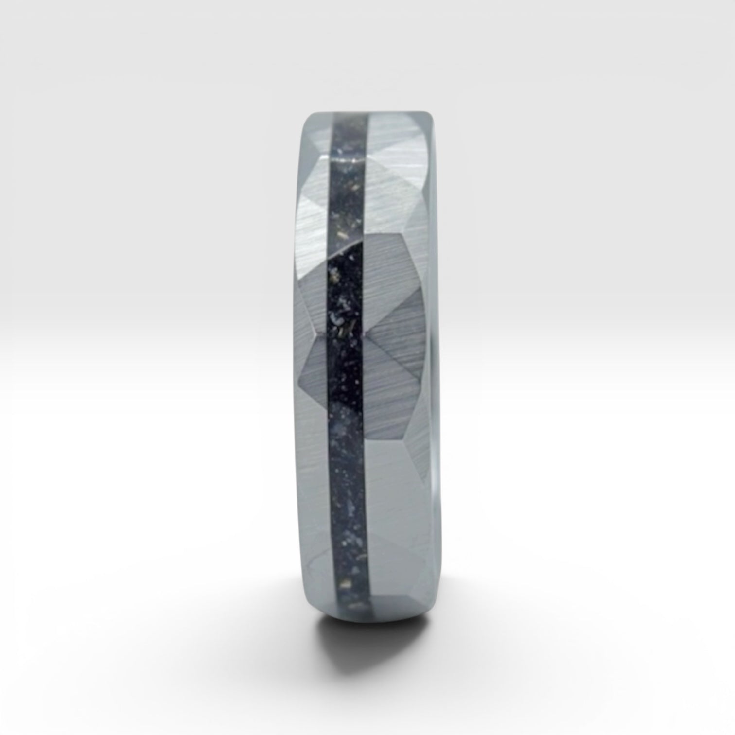 Faceted tungsten wedding ring with black tourmaline and 14k gold shavings inlay in a 2mm offset channel